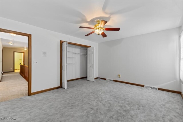 unfurnished bedroom featuring light colored carpet, a closet, and ceiling fan