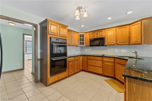 kitchen featuring tasteful backsplash, sink, dark stone countertops, and black appliances