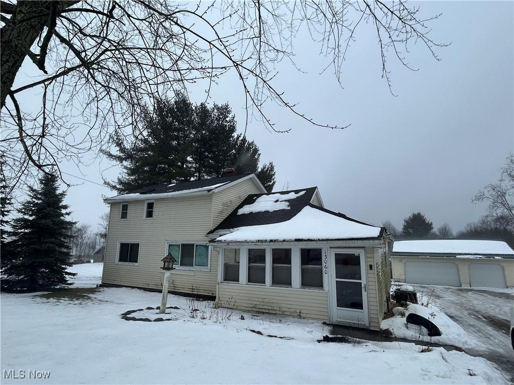 view of snow covered back of property