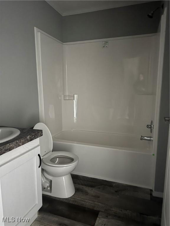 full bathroom with vanity, hardwood / wood-style floors, toilet, and washtub / shower combination