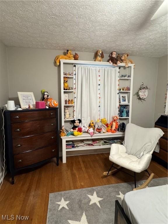 bedroom featuring hardwood / wood-style flooring and a textured ceiling