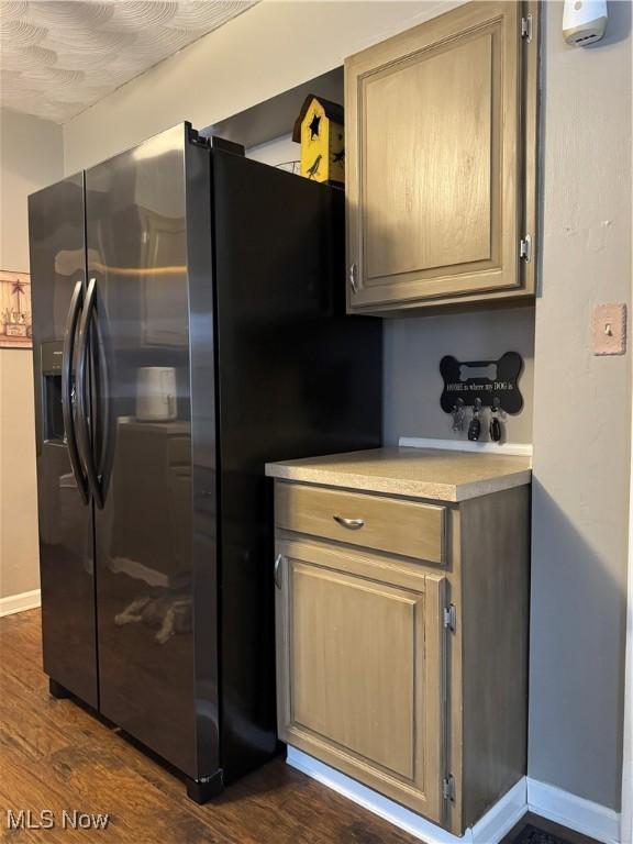 kitchen with dark hardwood / wood-style flooring and stainless steel fridge