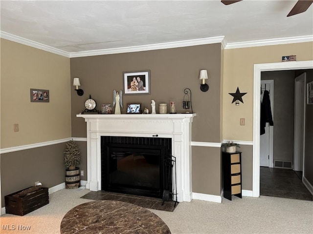 carpeted living room featuring crown molding, ceiling fan, and a fireplace