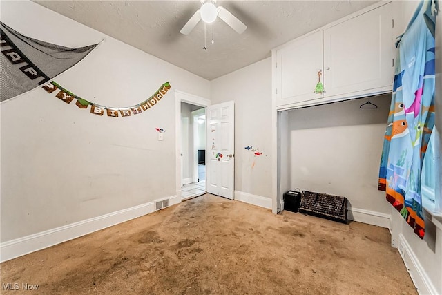 interior space with ceiling fan and light colored carpet