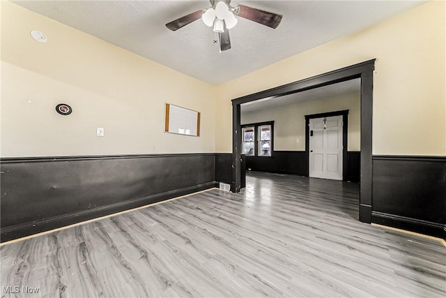 empty room with ceiling fan and light hardwood / wood-style floors