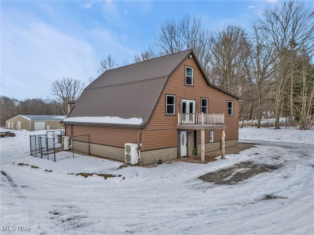 snow covered house featuring ac unit