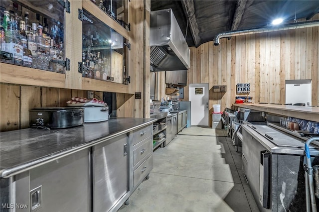 kitchen featuring wooden walls and range hood