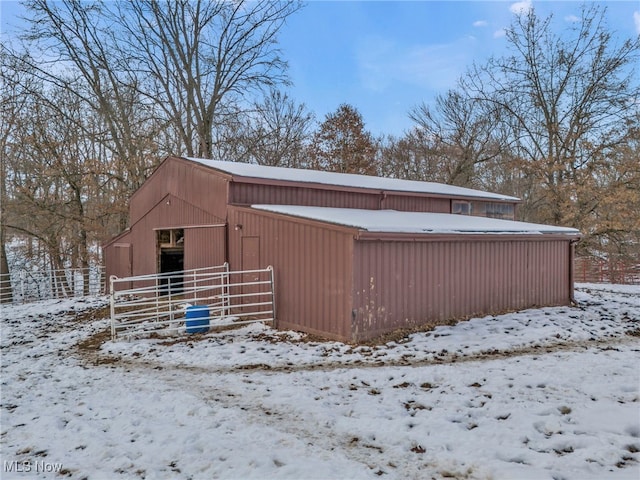 view of snow covered exterior featuring an outbuilding