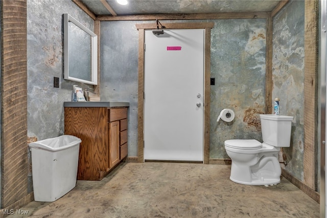 bathroom with vanity, concrete flooring, and toilet