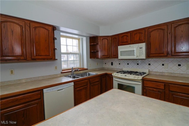 kitchen with white appliances, sink, and backsplash