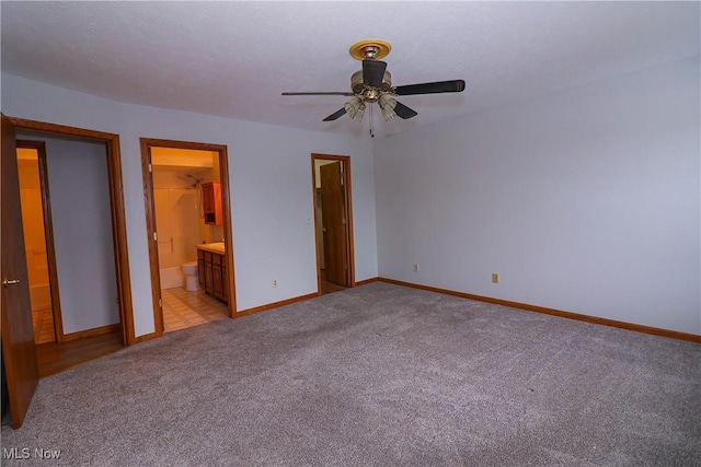 unfurnished bedroom featuring connected bathroom, light colored carpet, and ceiling fan