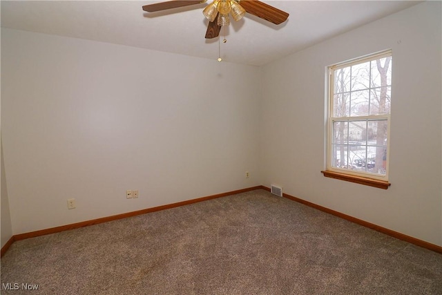 spare room featuring ceiling fan and carpet