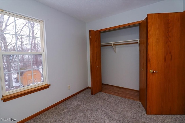 unfurnished bedroom with light carpet and a closet