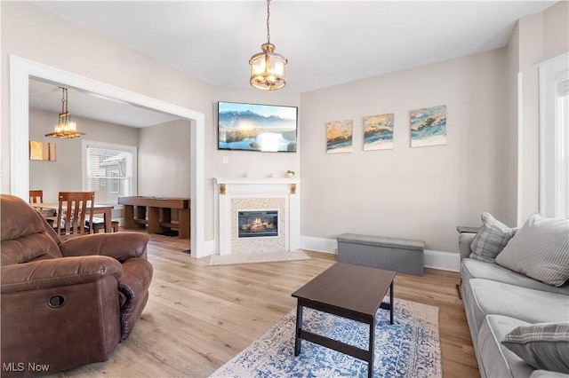 living room featuring an inviting chandelier and light hardwood / wood-style floors