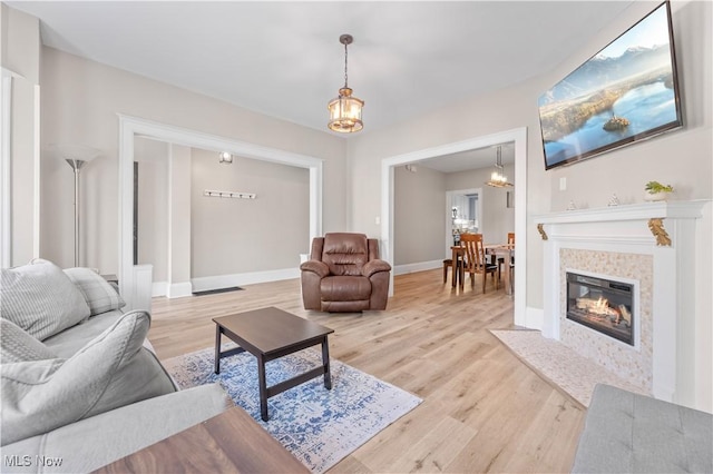 living room featuring a tiled fireplace and light hardwood / wood-style flooring