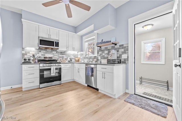 kitchen featuring white cabinetry, appliances with stainless steel finishes, and a wealth of natural light