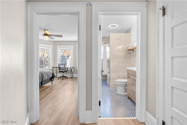 bathroom featuring toilet, a shower, vanity, ceiling fan, and hardwood / wood-style floors