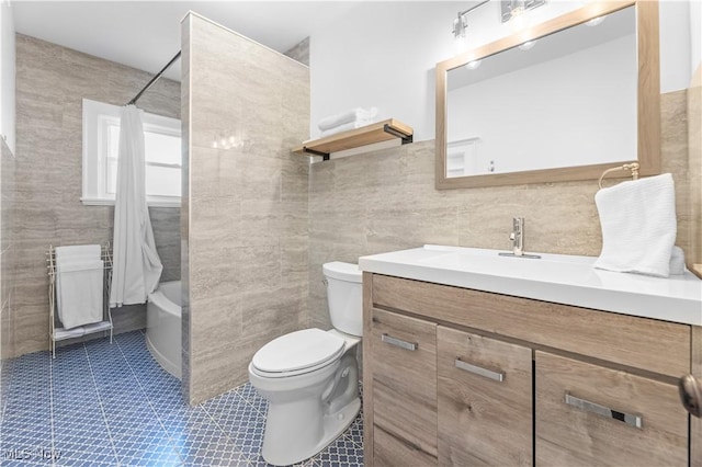 full bathroom featuring tile walls, shower / bath combination with curtain, vanity, toilet, and tile patterned floors