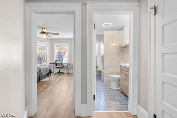 bathroom with hardwood / wood-style floors, a shower, vanity, ceiling fan, and toilet