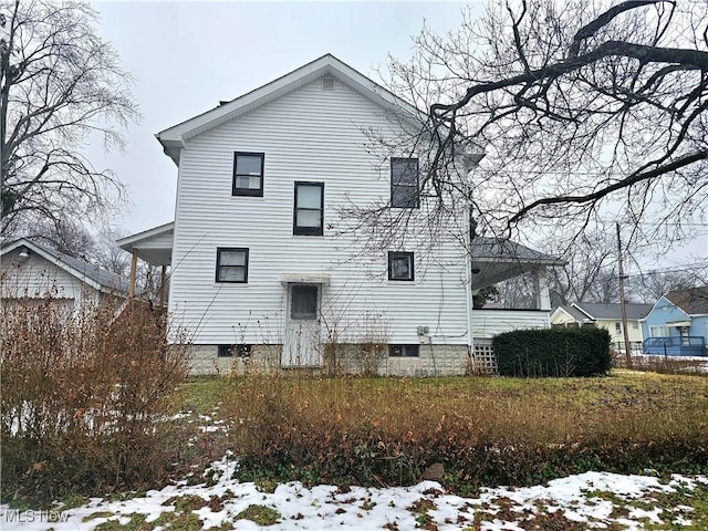 view of snow covered back of property