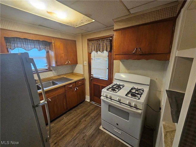 kitchen featuring dark wood-type flooring, white appliances, and decorative backsplash