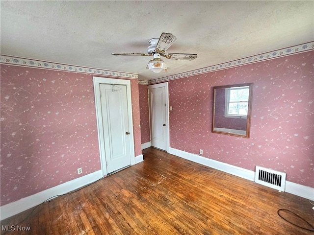 unfurnished bedroom with hardwood / wood-style floors, a textured ceiling, and ceiling fan