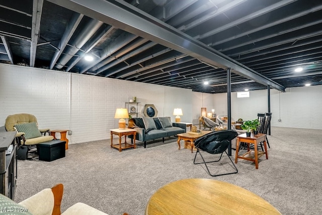 carpeted living room with brick wall