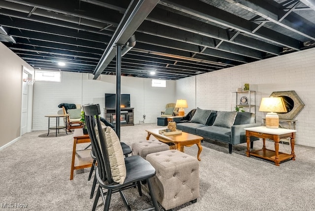 living room with carpet flooring, a healthy amount of sunlight, and brick wall