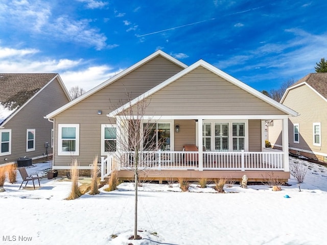 snow covered property featuring a porch and cooling unit