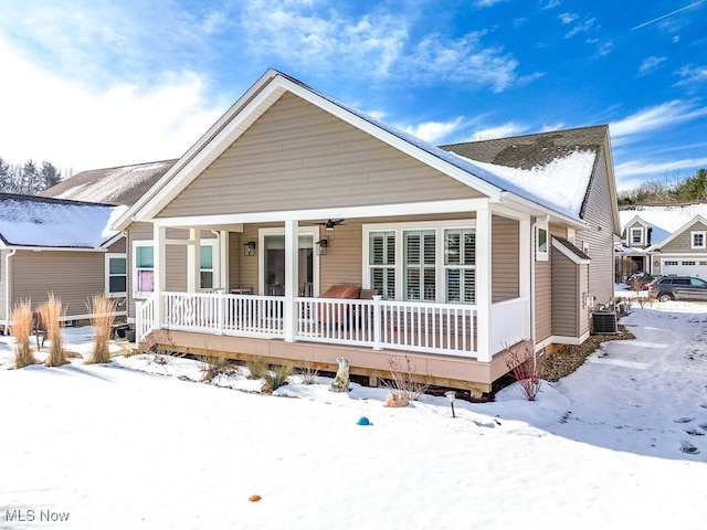 snow covered property featuring cooling unit and a porch