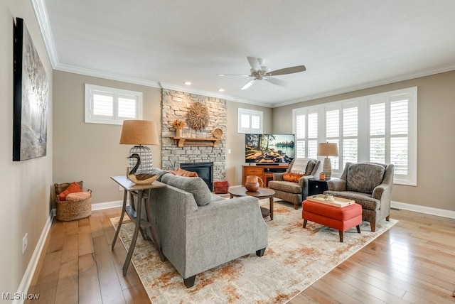 living room with crown molding, a stone fireplace, and light hardwood / wood-style floors