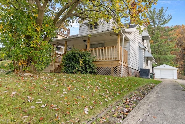 view of front of home with a garage, an outdoor structure, and a front lawn