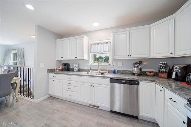 kitchen featuring white cabinetry, dishwasher, sink, range, and light hardwood / wood-style floors