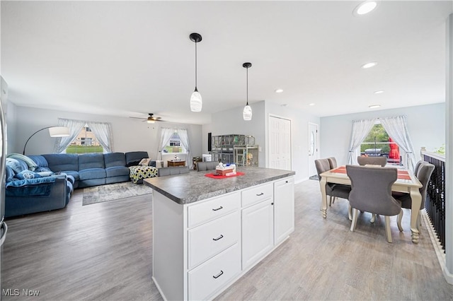 kitchen featuring a wealth of natural light, light hardwood / wood-style floors, a kitchen island, and white cabinets