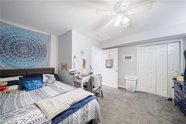 carpeted bedroom featuring ceiling fan and a closet