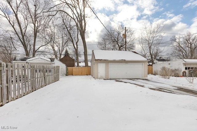 yard covered in snow with a garage and an outdoor structure