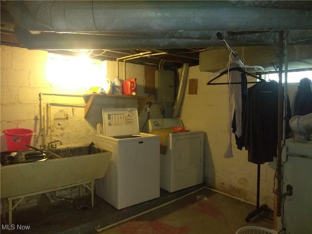 basement featuring washing machine and dryer, sink, and electric panel