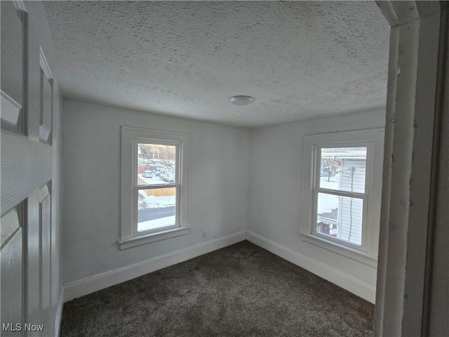 carpeted spare room with a textured ceiling