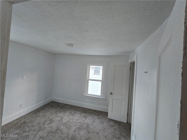 empty room with a textured ceiling and carpet