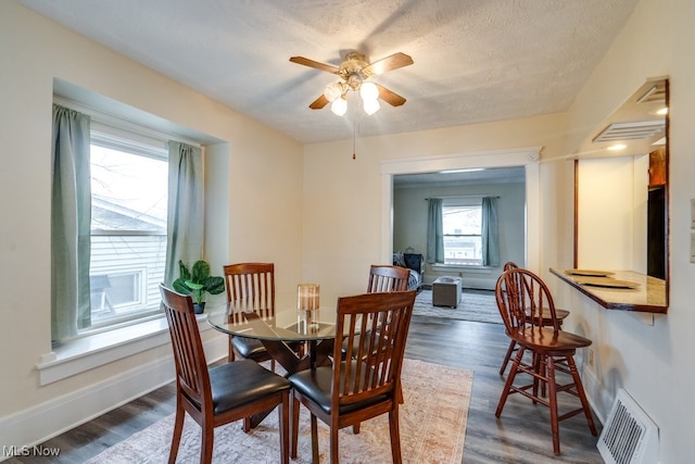 dining area featuring ceiling fan, dark hardwood / wood-style floors, and a textured ceiling