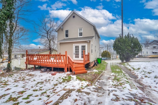 snow covered rear of property featuring a deck