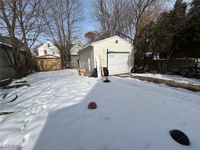 yard covered in snow with a garage and an outbuilding