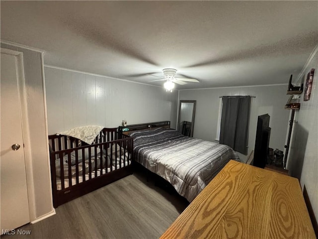 bedroom with ceiling fan, hardwood / wood-style flooring, and a textured ceiling