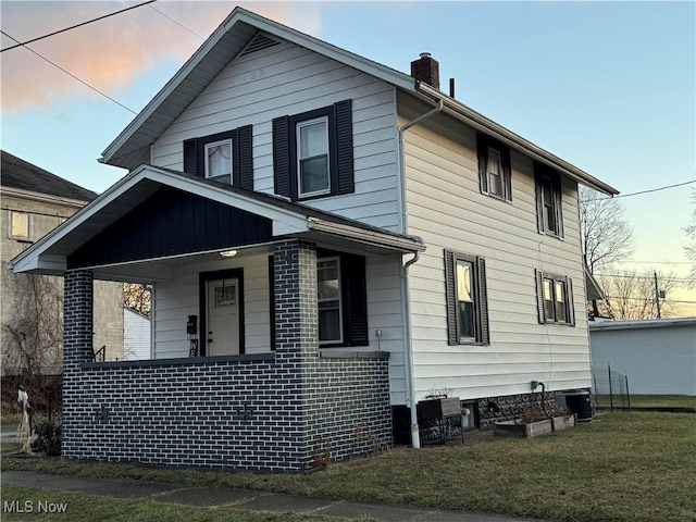 property exterior at dusk featuring cooling unit, a porch, and a lawn