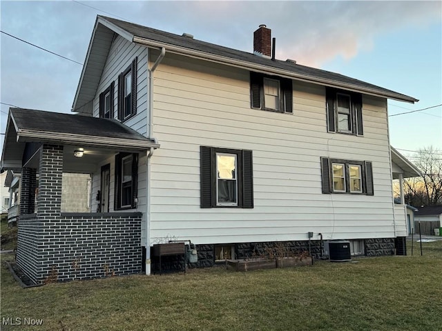 view of home's exterior featuring cooling unit and a lawn