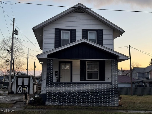 view of front of house with a storage unit and covered porch