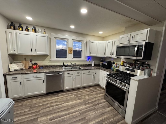 kitchen featuring hardwood / wood-style flooring, appliances with stainless steel finishes, sink, and white cabinets