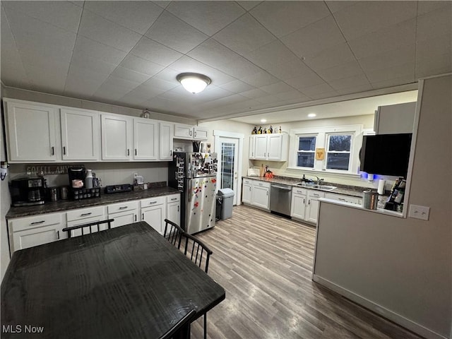 kitchen with white cabinetry, sink, light hardwood / wood-style flooring, and stainless steel appliances