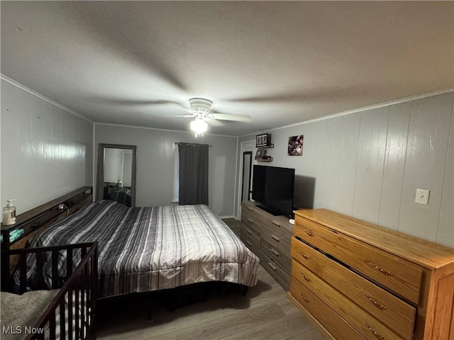 bedroom featuring hardwood / wood-style flooring, crown molding, and ceiling fan