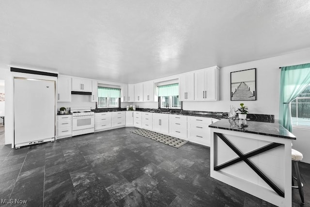 kitchen featuring white cabinetry, fridge, and white range with gas cooktop